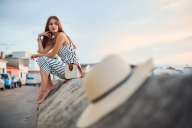 Şehrin yaşlı kesiminde sokakta poz veren genç, zarif, çıplak ayaklı bir kadın..