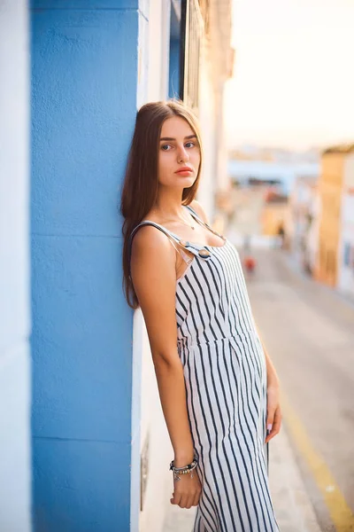 Potret busana wanita muda elegan berpose menghadap dinding biru . — Stok Foto