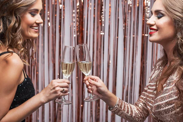 Portret dwóch pięknych eleganckich kobiet brzęczących kieliszkiem szampana — Zdjęcie stockowe