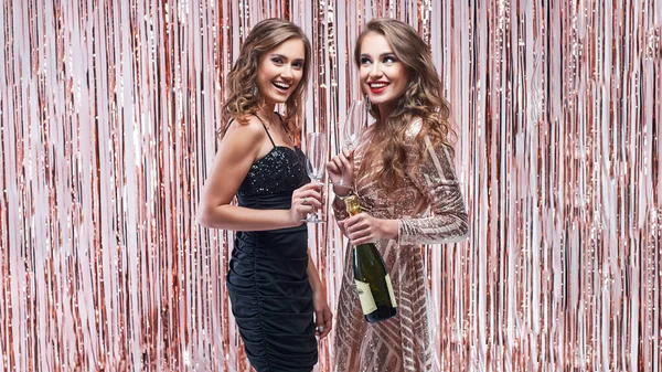 Två vackra eleganta kvinnor dricker champagne mot mousserande — Stockfoto