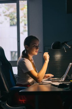 Kız bilgisayarın başında çalışıyor. Ofiste çalışmaya odaklanmış. Yeni bir fikir arıyor.