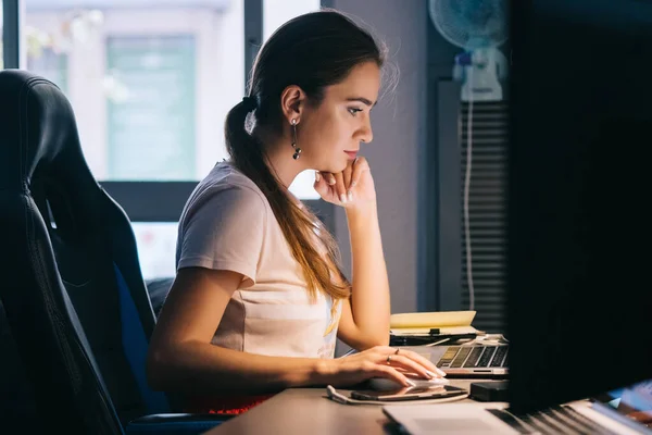 girl working at the computer concentrated on the office work on the background of the fan