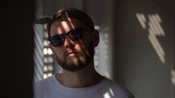 Portrait of bearded man in a white T-shirt standing near the gate — Stock Video