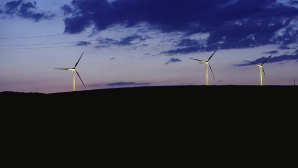 Molinos de viento en el horizonte después del atardecer con nubes al atardecer — Vídeos de Stock