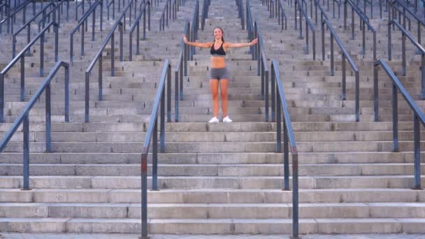 Χαμογελαστό κορίτσι μελαχρινή κάνει πρωινή άσκηση στις σκάλες — Αρχείο Βίντεο