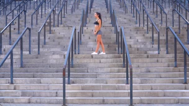 Jovem fazendo exercícios de fitness e exercícios de alongamento para a saúde nas escadas do estádio — Vídeo de Stock