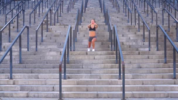 Довге волосся молода спортсменка робить фітнес-тренування і розтягує вправи для здоров'я на сходах стадіону — стокове відео