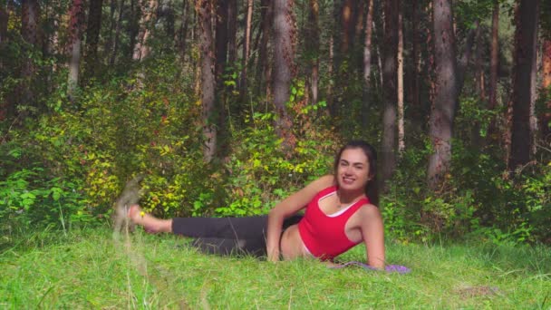 Μελαχρινή νεαρή γυναίκα, κάνοντας ασκήσεις αθλητισμό στο ηλιόλουστο πάρκο — Αρχείο Βίντεο