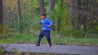 Küçük çocuk oyuncak jiroskop beyblade açık sonbahar parkta oynuyor