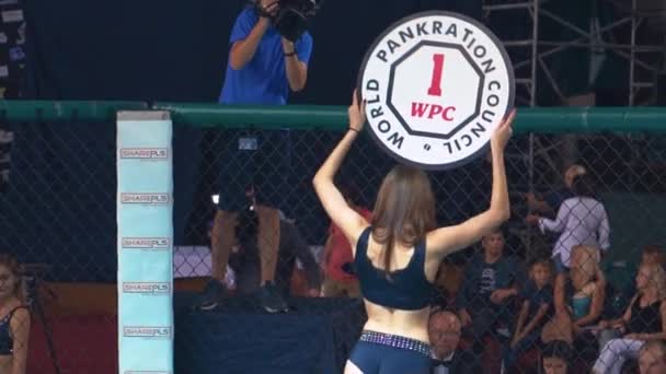 KIEV, Ucrania - 22 de septiembre de 2018: Girl sostiene una tabla anuncia el número de la ronda durante el campeonato de MMA en octágono — Vídeo de stock