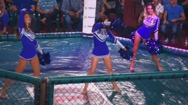 Kiew, Ukraine - 22. September 2018: Cheerleader-Mädchen in einem blauen Kleid tanzen mit Bommelmützen im Achteck — Stockvideo