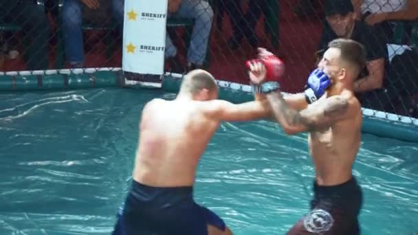 KIEV, Ucrania - 22 de septiembre de 2018: Dos fuertes oponentes de MMA se golpean y patean entre sí durante la lucha en octágono — Vídeo de stock