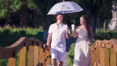 Erkek ve bir kadın elinde bir şemsiye ile bir köprü yürüyüş seviyorum