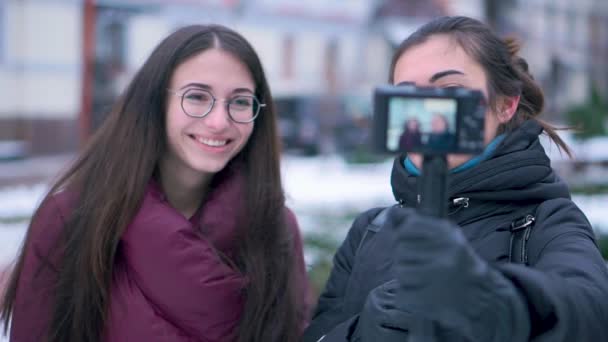 Две брюнетки подруги и блоггеры записывают видео на камеру во время зимних поездок — стоковое видео