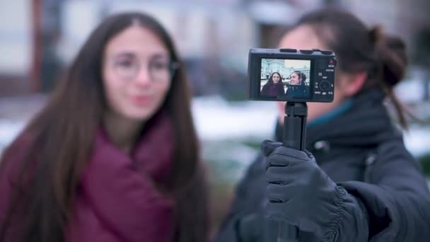 Due bruna giovane donna registrazione video per vlog sulla macchina fotografica all'aperto in giornata invernale — Video Stock