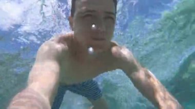 Genç adam bir mavi temiz suya dalış