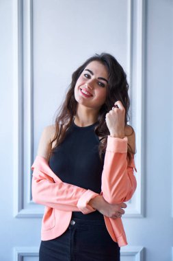 Çekici genç gülümseyen esmer kız beyaz bir stüdyoda portresi