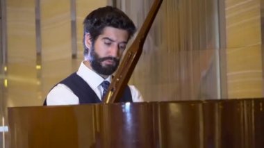 Virtüözü müzik keyfi fortepiano oynayan yakışıklı sakallı piyanist görünümünü kapat