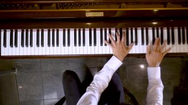 Üst görünüm oynarken piyano klavye ve müzisyen eller