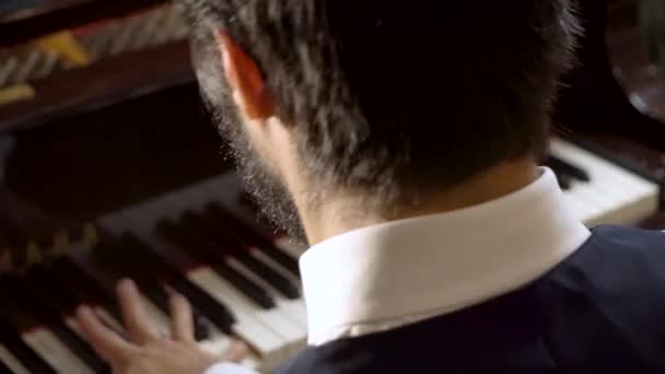 Піаніст грає на фортепіано, сидячи на спині — стокове відео