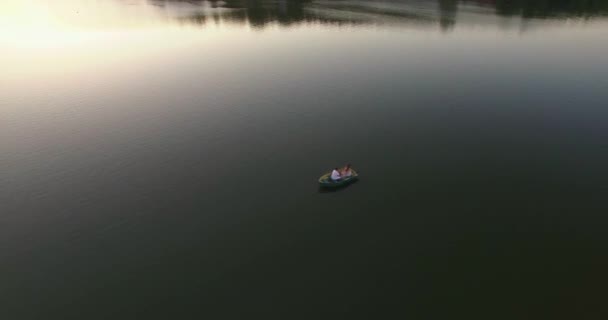 Homem e mulher ao pôr-do-sol raios de sol na história de amor barco — Vídeo de Stock