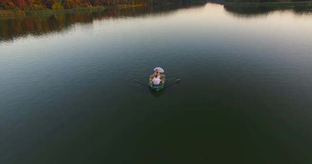 Жених и невеста с белым зонтиком в лодке история любви на закате солнечных лучей — стоковое видео