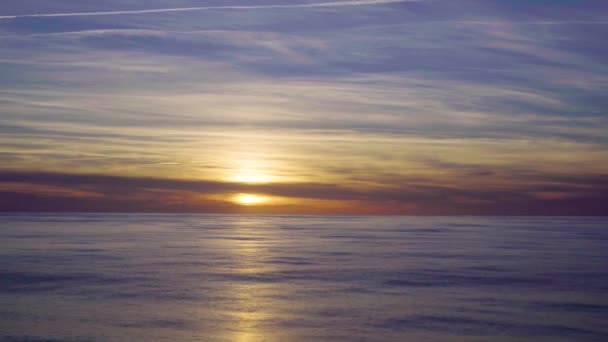 Krajobraz pomarańczowy zachód słońca z odbiciem słońca w wodzie i jasnym błękitnym niebie — Wideo stockowe