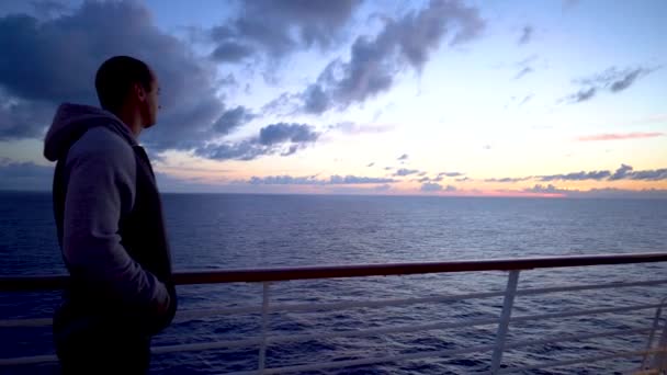 Retrato joven se volvió hacia el horizonte observando el amanecer sobre el océano — Vídeo de stock