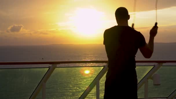 Jeune homme athlétique fait un exercice avec une corde sautante pendant le lever du soleil — Video