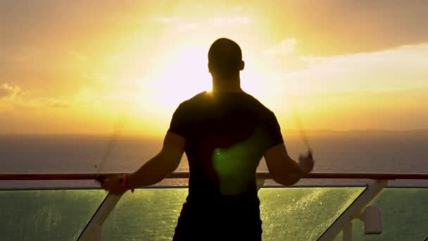 Jonge atleet maakt een oefening met een springtouw tijdens zonsopgang — Stockvideo