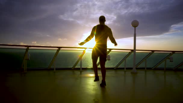 Sportman maakt een oefening met een springtouw tijdens zonsopgang — Stockvideo