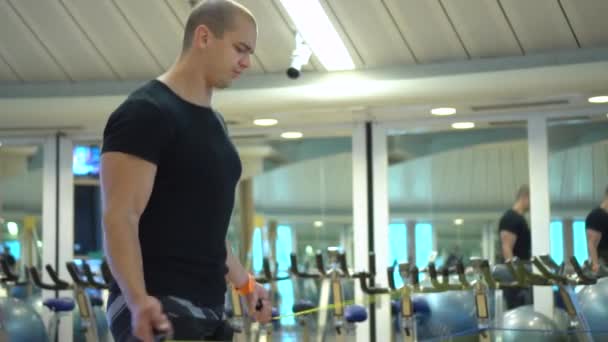 Young athletic man trains with a jumping rope in gym — Stock Video