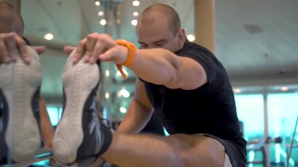 Jeune homme athlétique fait des étirements exercice dans la salle de gym — Video