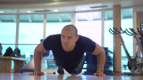 Fiatal atlétikai férfi teszi push-up testmozgás edzőteremben — Stock videók
