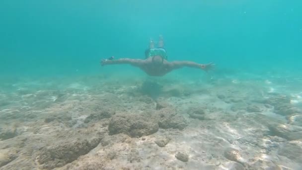 Молодой улыбающийся мужчина ныряет бесплатно под воду GoPro Hero7 — стоковое видео