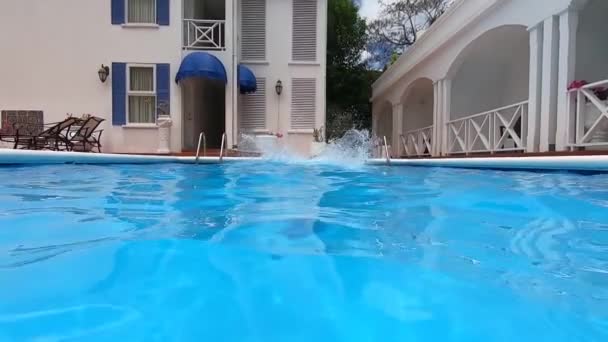 Молодой человек прыгает в бассейн GoPro Hero7 — стоковое видео