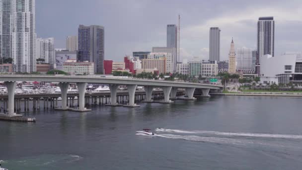 Miami, Florida-Červenec 6, 2019: městský mrakodrap v centru Miami a pohybující se čluny pod mostem — Stock video