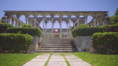 Adam atlet başının üzerinde duran antika sütunlar arasında dengeleme