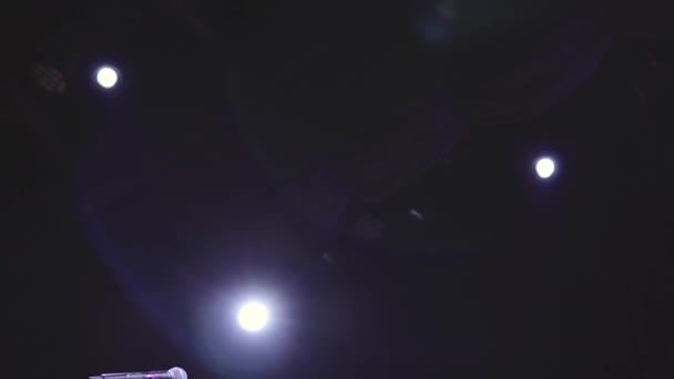 Lege podium met gitaar microfoon en stoel wacht een muzikant in het donker — Stockvideo