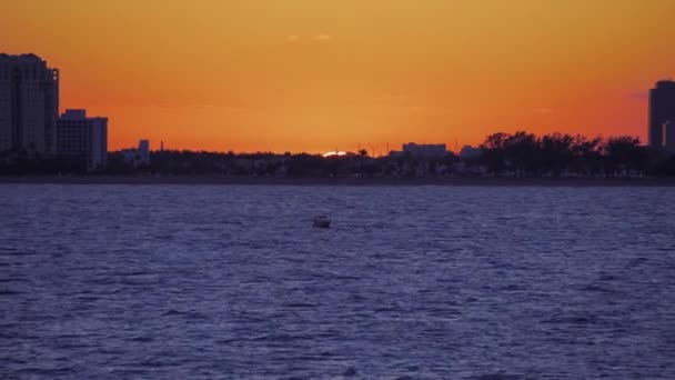 Човен у морі перед заходом сонця помаранчеве сонце над лінією горизонту — стокове відео