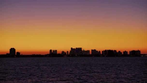 Paisaje nocturno de la ciudad con edificios sobre fondo de cielo naranja atardecer de colores — Vídeo de stock