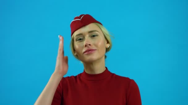 Stewardessa dostosowuje jej kapelusz i uśmiecha się — Wideo stockowe