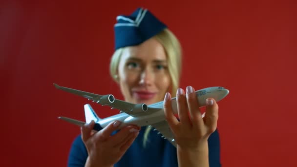 A aeromoça sorrindo com um avião de brinquedo em suas mãos — Vídeo de Stock