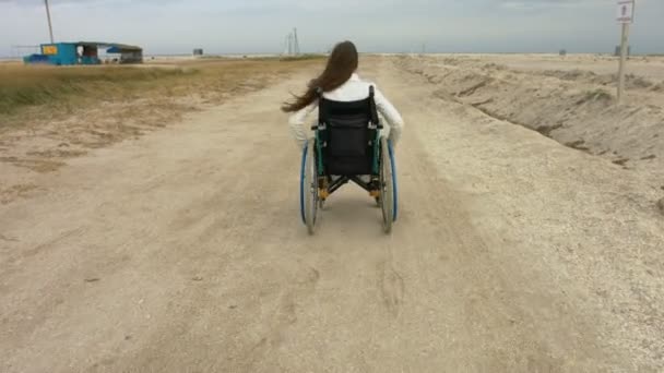 Прогулки для инвалидов в инвалидной коляске вдоль пляжа — стоковое видео