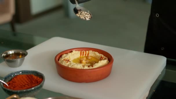 De chef-kok bereidt de hummus Stockvideo's