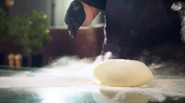 Şefin ellerinin unun içine hamur attığı yavaş çekim.