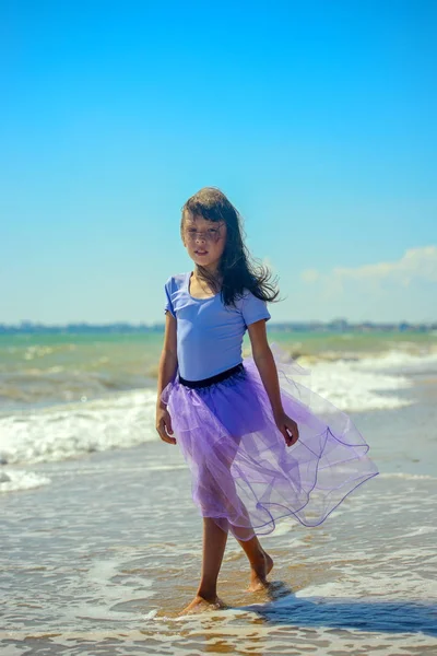 귀여운 보라색 수영복에 화창한 날에는 해변을 카메라에서 보이는 머리는 바람에 — 스톡 사진
