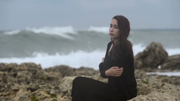 Verdrietig Meisje Zittend Een Zwarte Jurk Rotsen Aan Zee Tijdens — Stockvideo