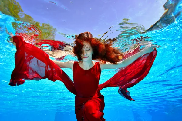 Charming Girl Red Hair Swims Underwater Pool Red Dress Blue — Stock Photo, Image