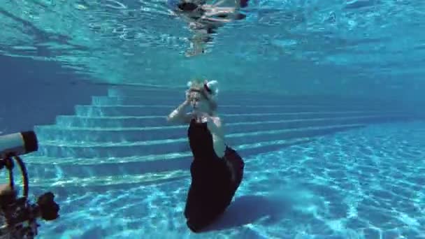 摄影师专业游泳和拍摄水下在泳池美丽的女孩模型与白色的头发在西装金牛座 慢动作 Fps — 图库视频影像